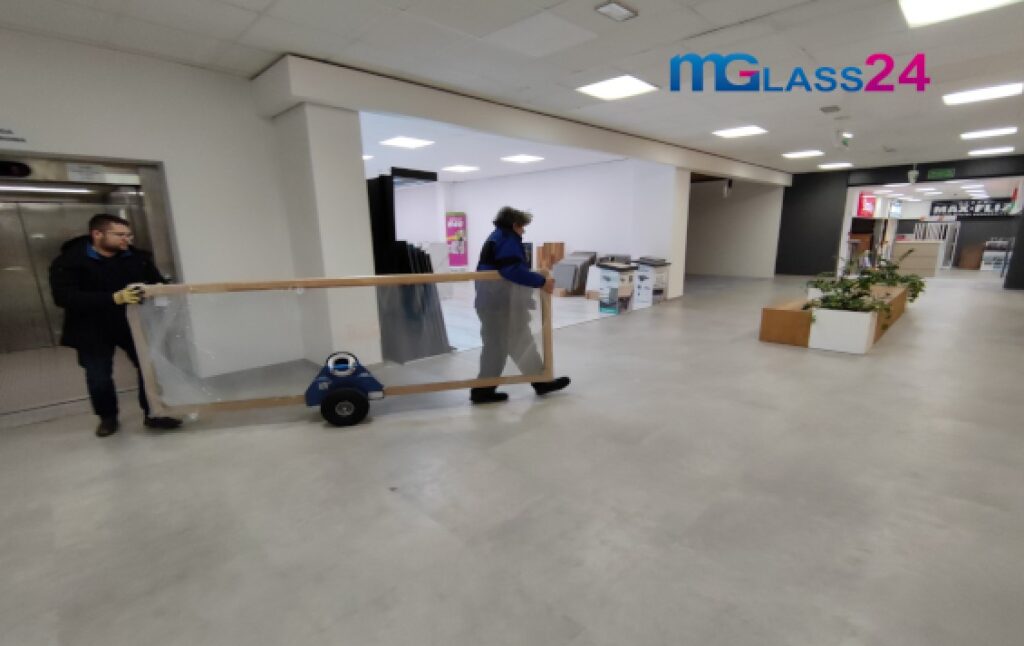 szklarze transportują szkło przy pomocy wózka do transportu