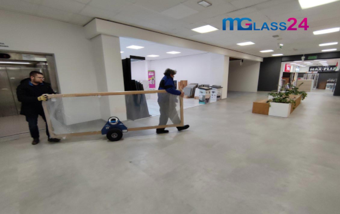 szklarze transportują szkło przy pomocy wózka do transportu