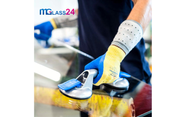 bezpieczne przenoszenie szyb szklarz przenosi szybę za pomocą przyssawki